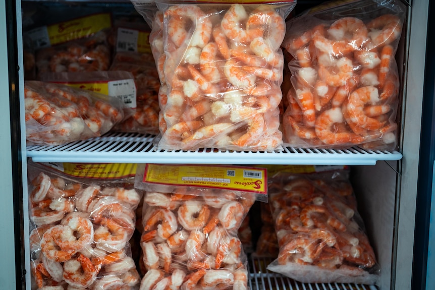 Bags of frozen prawns in a freezer