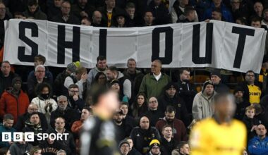 Wolves fans hold a Shi Out banner
