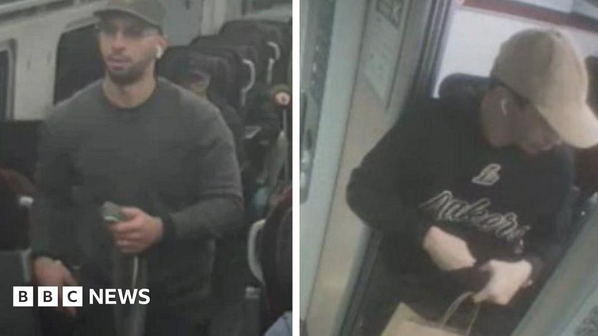 The two men pictured in CCTV from the train. The one on the left is wearing a brown jumper with a cap and is holding a long fabric object in his hand. The man on the right is wearing a dark jumper with words on that are hard to read, as well as ear buds in his ears and a cream cap.