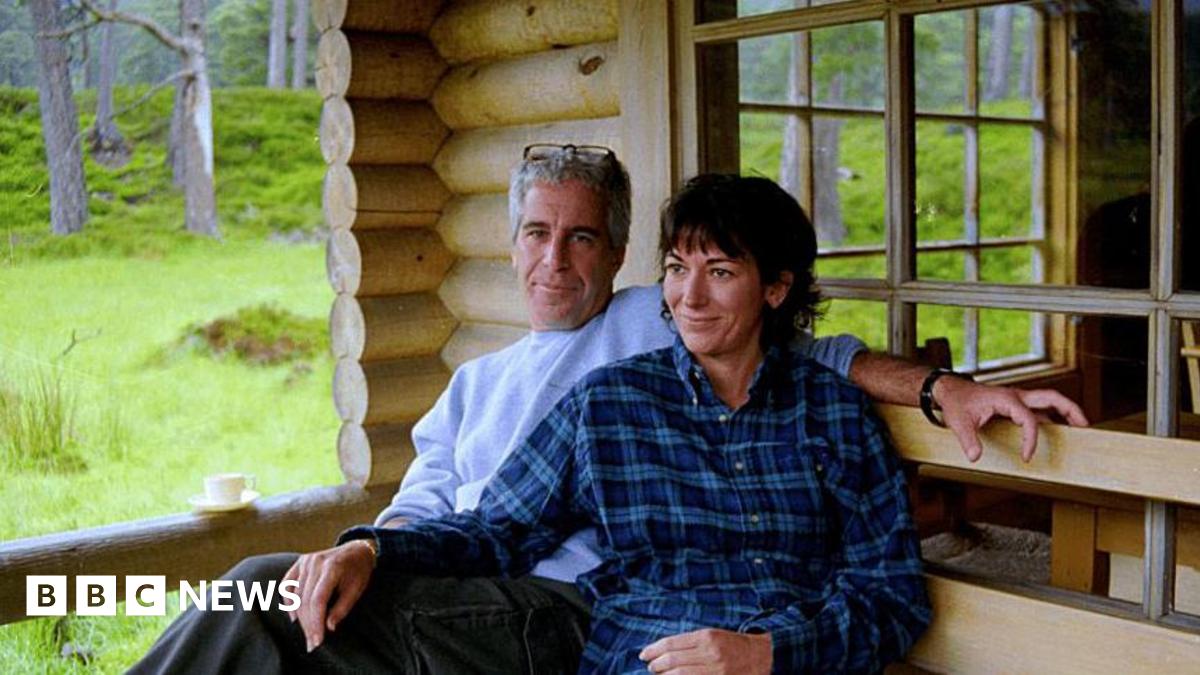 An undated photo released by the US justice department shows Jeffrey Epstein and his co-conspirator Ghislaine Maxwell seated close together outside a wooden home, appearing to be a cabin of some kind in a wooded area.
