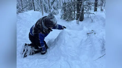 Handout A boy in a thick coat playing in the snow. 