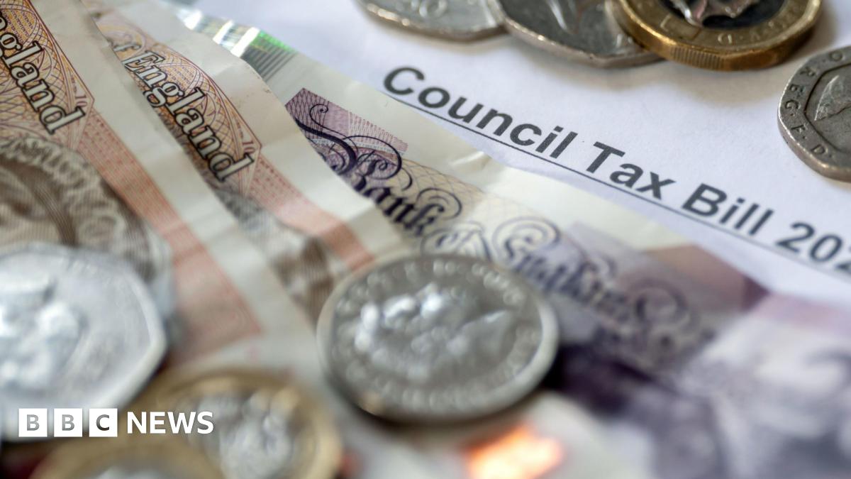 Coins and notes of different values sit on top of a council tax bill.