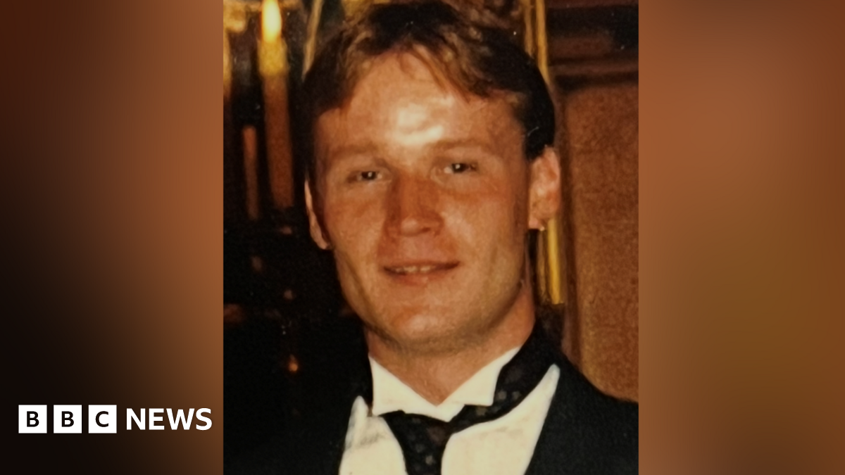 Steven Shevels with short brown hair. He is smiling and wearing a smart black jacket, black tie and white shirt.