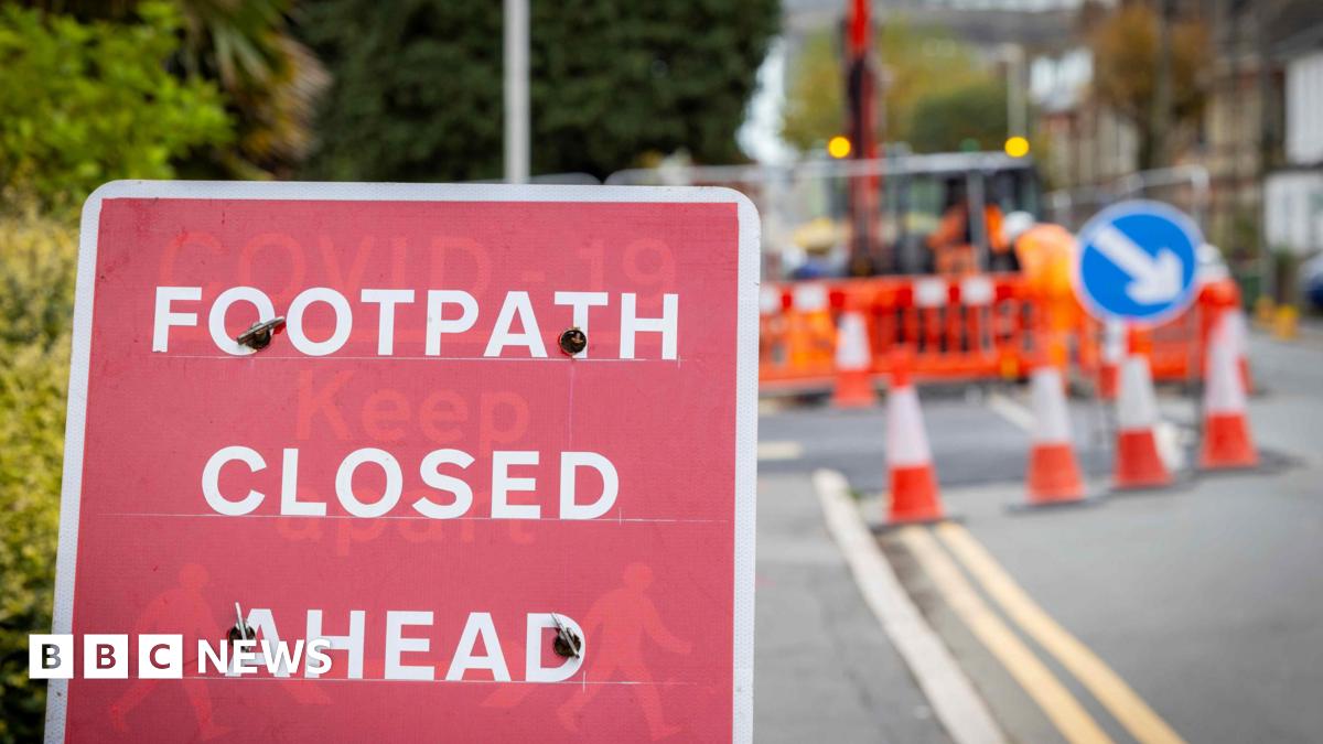 Generic image of roadworks in the UK with a sign that reads Footpath Closed Ahead
