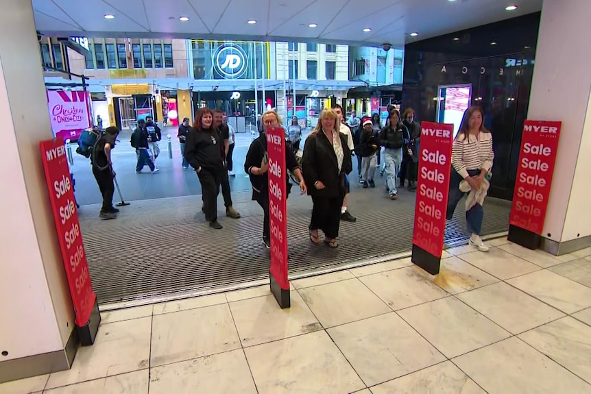 Shoppers walking into a store.