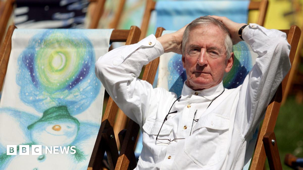Author Raymond Briggs sat on a deck chair. He the deck chairs have drawings of The Snowman on them.