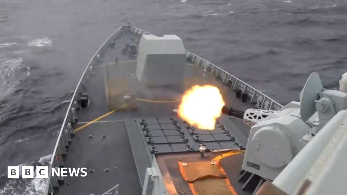 View of the tip of a war ship as it fires towards the sea