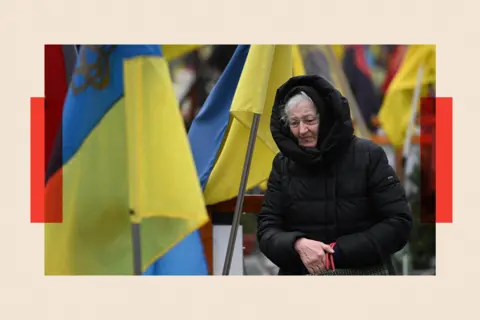 AFP via Getty Images A woman mourns among graves of Ukrainian servicemen at the Lychakiv cemetery