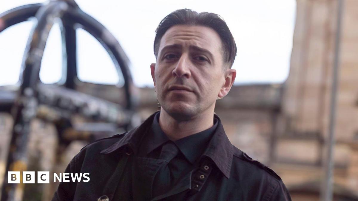 A 37-year-old man with slicked-back black hair, wearing a black shirt, black tie, and black jacket outside the High Court in Edinburgh
