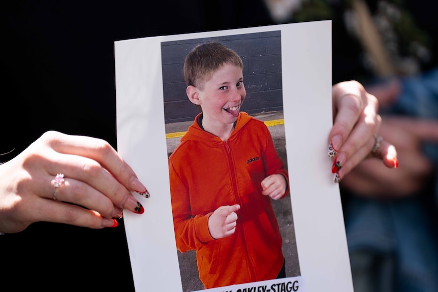 Hands holding an image of a boy