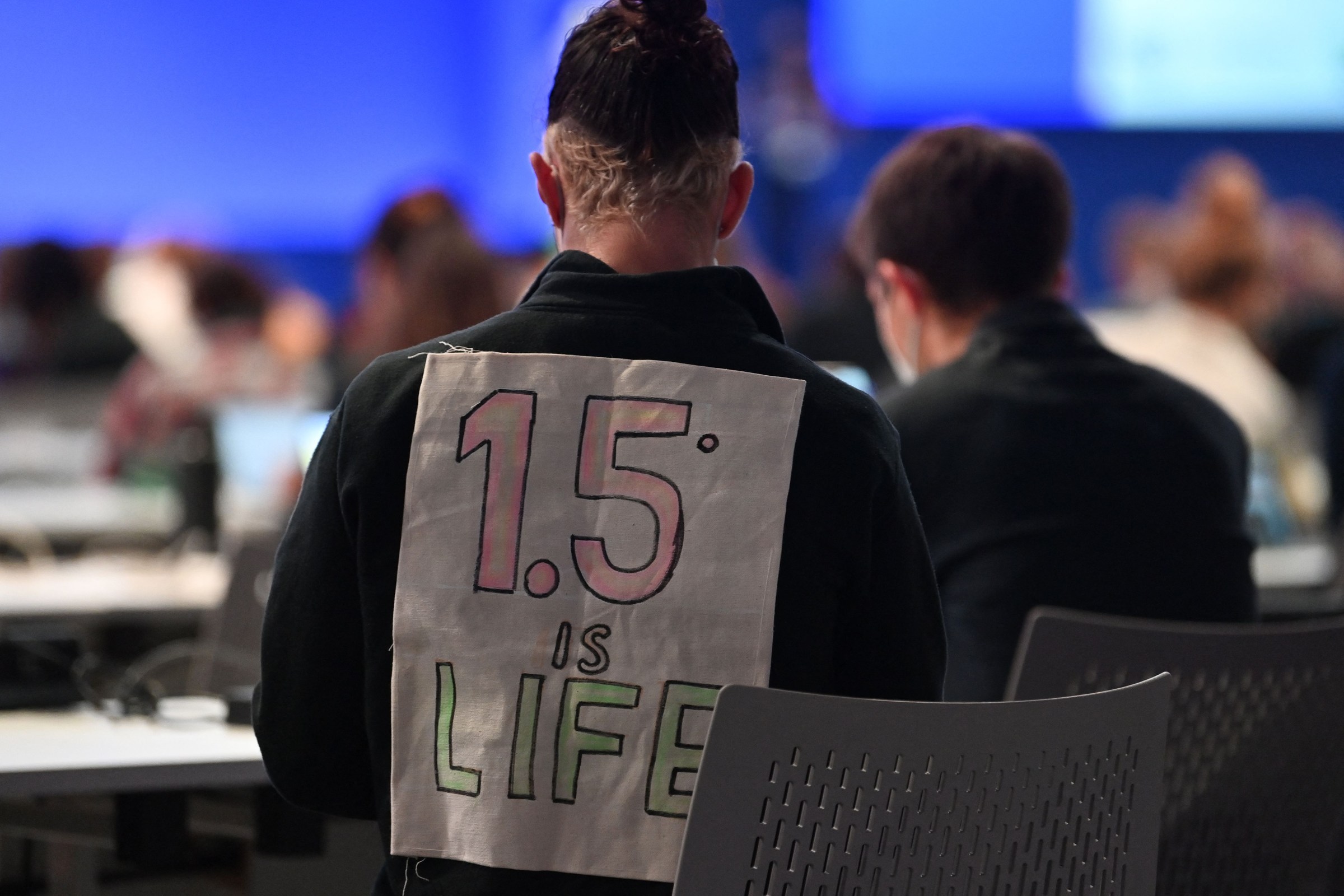 A sign posted behind someone’s back reads “1.5C is life”
