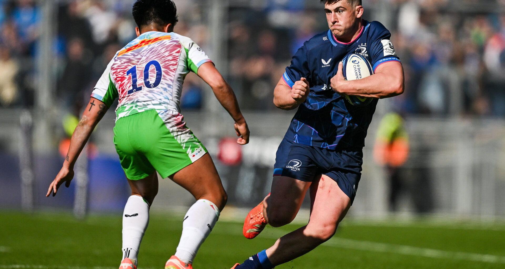 Leinster's Dan Sheehan runs with the ball as Harlequins' Marcus Smith prepares to challenge during the 2025 European Rugby Champions Cup round-of-16 match.