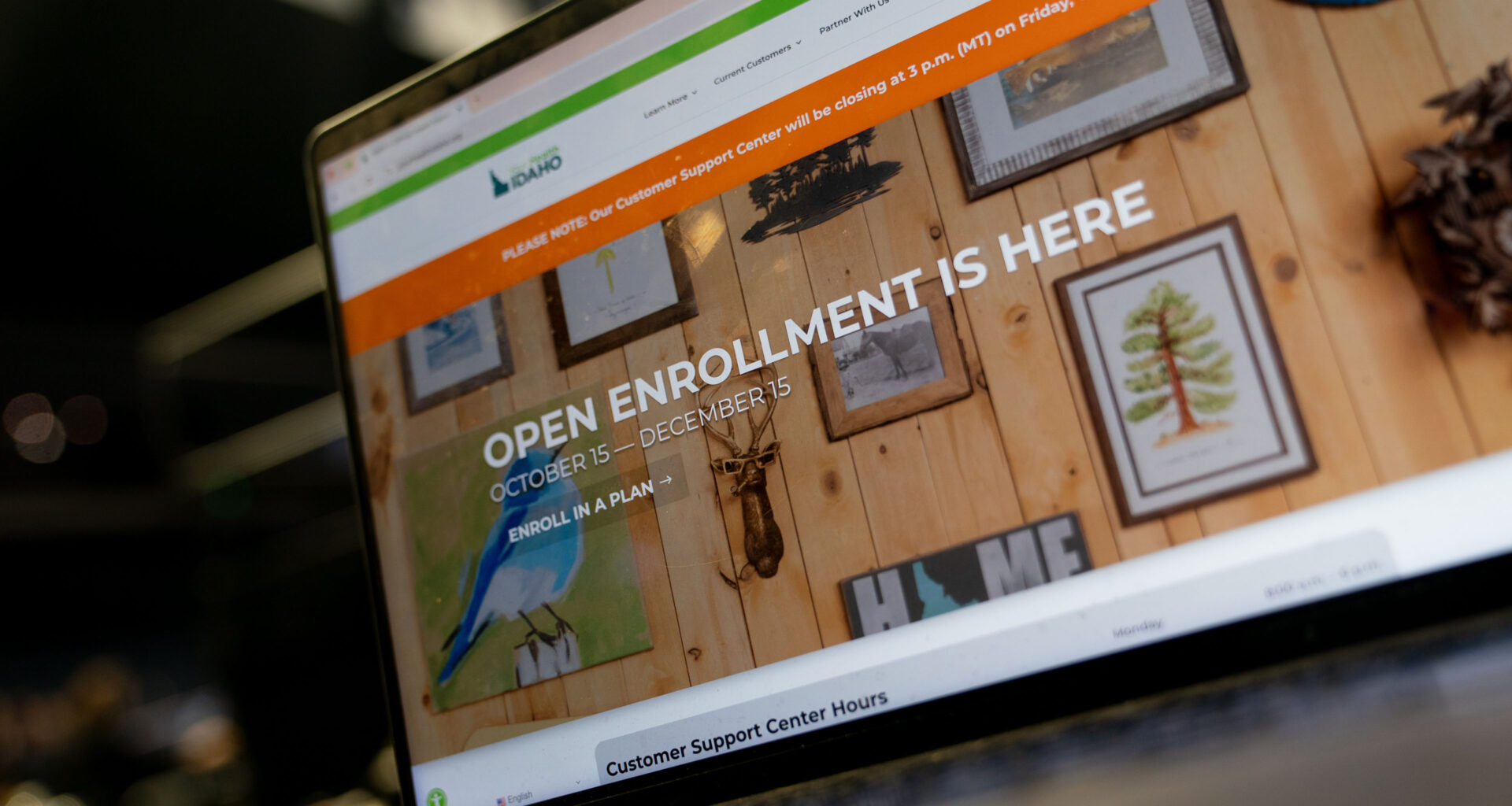 A laptop screen shows Idaho's Affordable Care Act marketplace website, with "Open Enrollment Ends December 15" in all-cap tyoe.