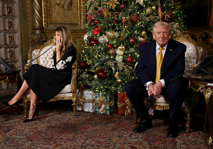 Donald Trump and Ivanka Trump seated near a decorated Christmas tree while making phone calls on Christmas Eve.