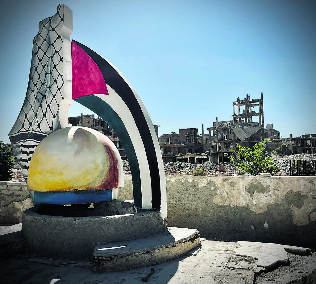 A monument in the Yarmouk district of Damascus stands in front of destroyed buildings. Once home to Syria’s largest Palestinian community, the area remains largely in ruins after years of fighting 