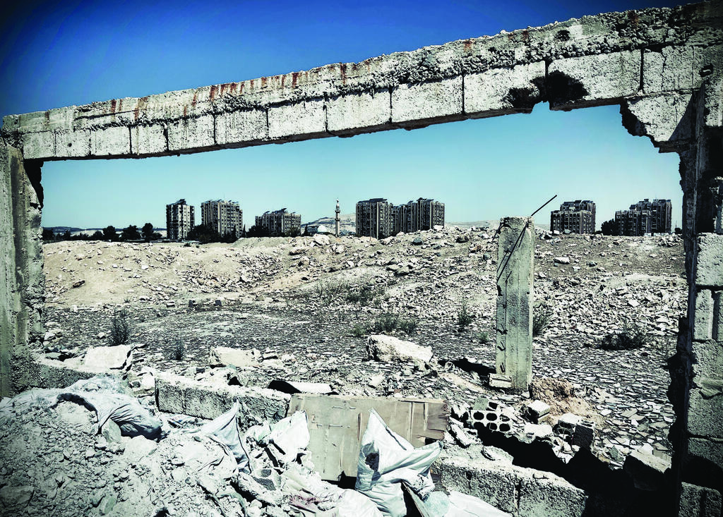War-damaged buildings and rubble are seen on the outskirts of Damascus. Much of the capital remains physically intact, but surrounding districts still bear deep scars from more than a decade of conflict 