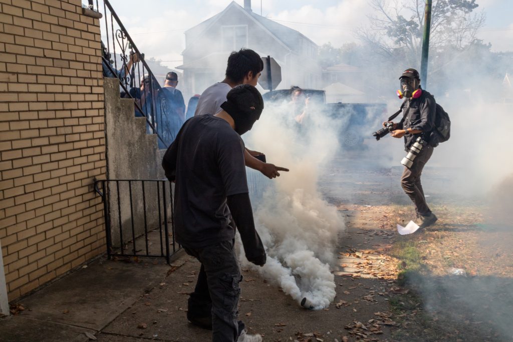 Agents deploy tear gas and smoke grenades during a clash between federal agents and residents at 105th and Avenue N on Chicago's East Side on Oct. 14, 2025.