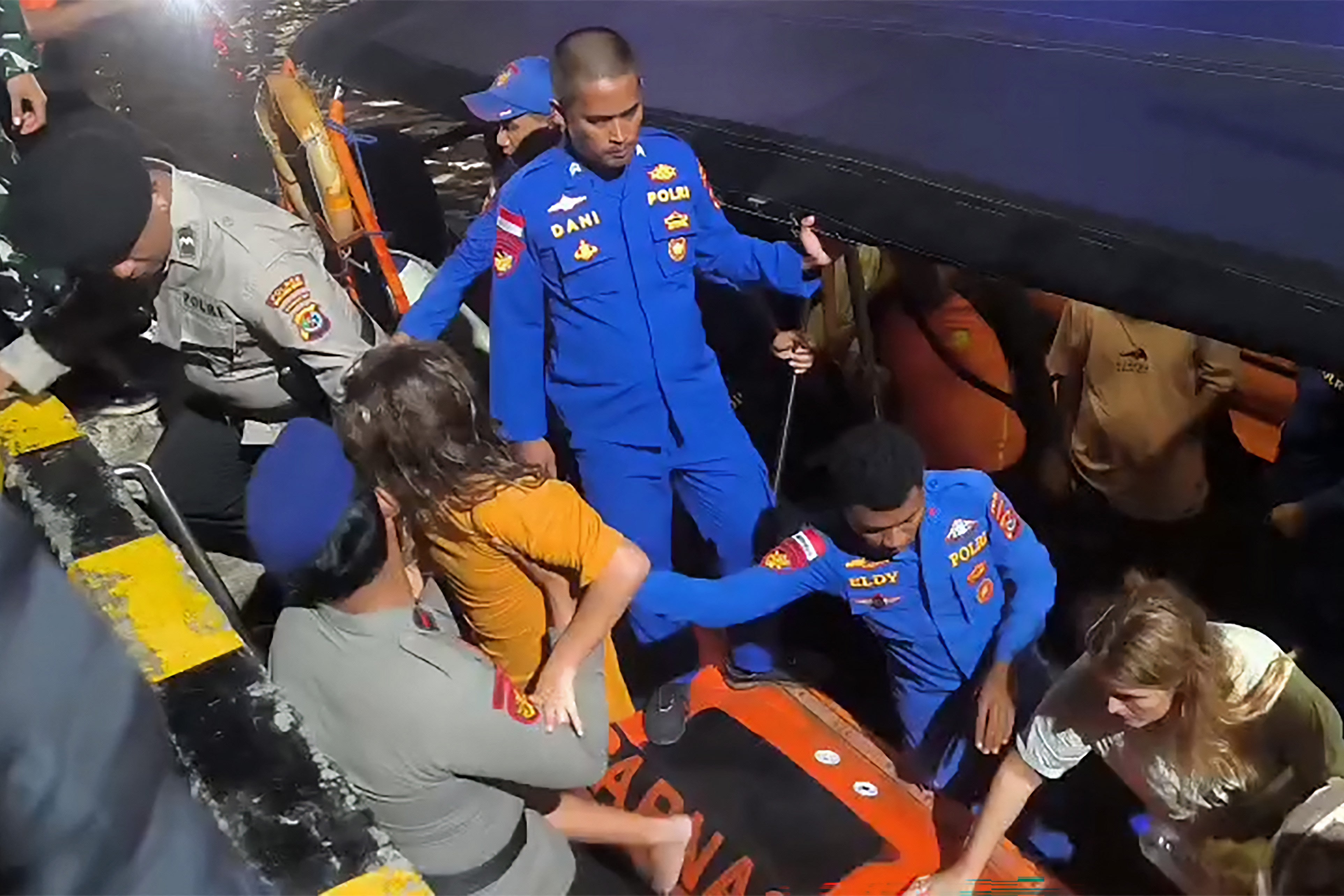 Members of search and rescue teams evacuate foreign tourists in the waters of Padar Island