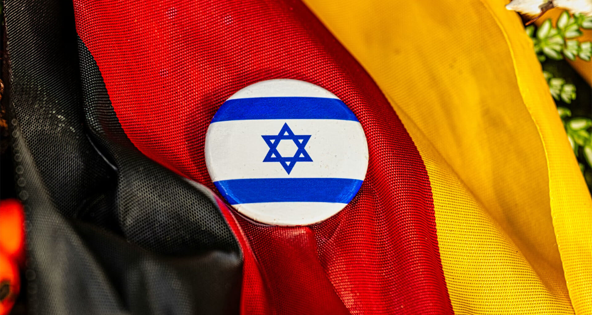 Israeli button on top of a German flag