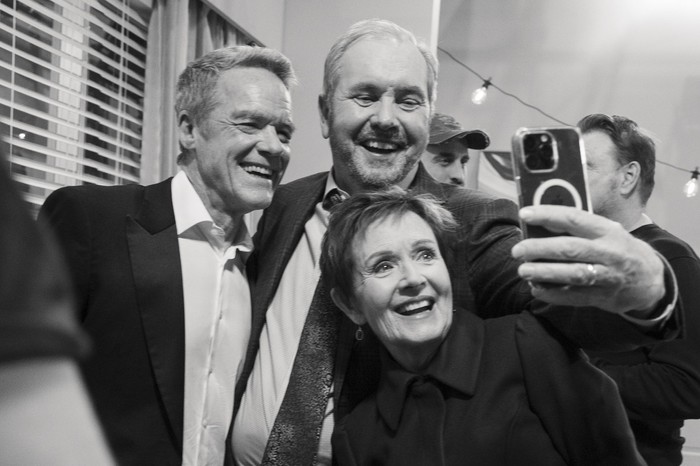 Stefan Dennis, Alan Fletcher and Jackie Woodburne take a selfie on the set of Neighbours in a greyscale image