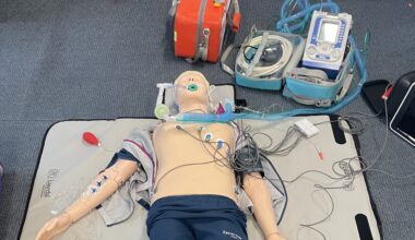 A human sized training manikin with wires connected to it's chest.