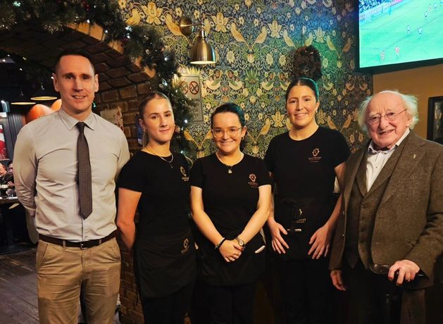 Michael D Higgins visits Galway pub posing for photo with delighted staff