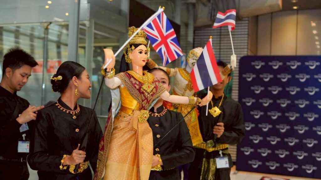 Traditional Thai performers wave UK and Thai flags at Suvarnabhumi Airport to celebrate one million UK visitors to Thailand.