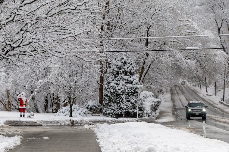 A Santa statue “waves” to drivers along Brace Road in Cherry Hill on Dec. 14, 2025. The Philly region may see its second snowfall of the season on Friday night.