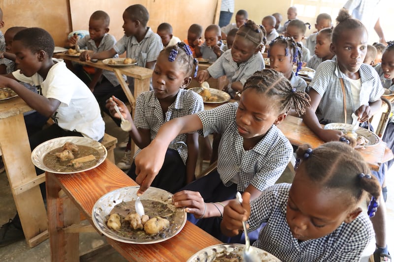 Primary school students eat their lunch in their classroom in Haiti.