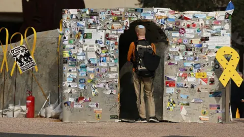 Reuters A person enters a makeshift tunnel symbolizing Hamas's tunnel network in Gaza, at Hostages Square" in Tel Aviv, Israel (14 January 2025)