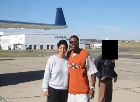US Department of Justice Actor Chris Tucker seen posing with convicted Epstein associate Ghislaine Maxwell. They are on a tarmac at an airport posing near a jet. 