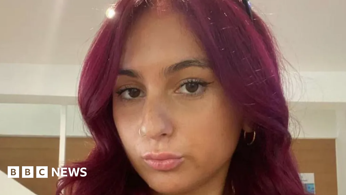 A young woman with red hair poses in a selfie