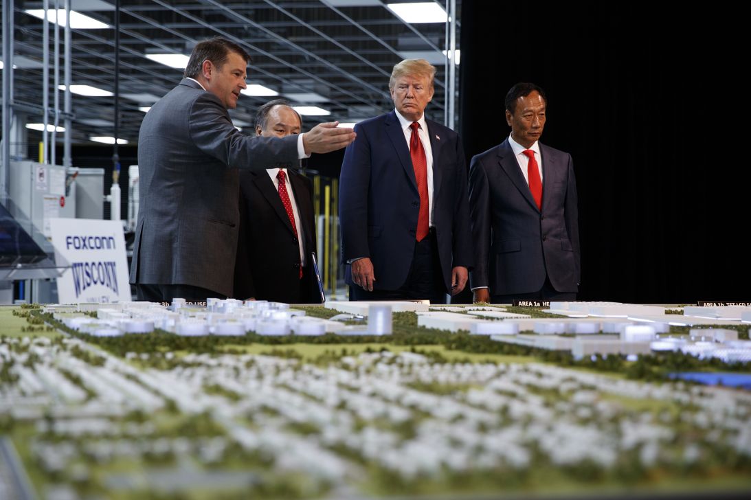 In this June 28, 2018 photo, President Donald Trump takes a tour of Foxconn with Foxconn chairman Terry Gou, right, and CEO of SoftBank Masayoshi Son in Mt. Pleasant, Wisconsin.