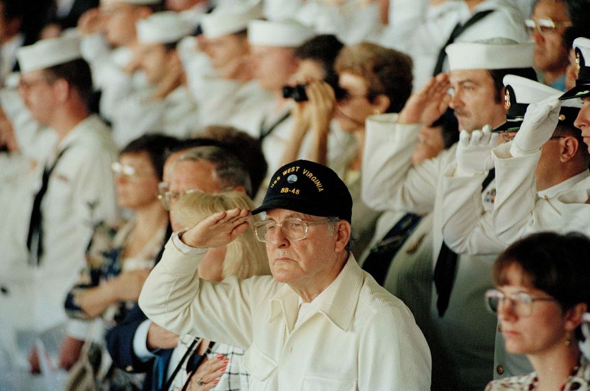 Pearl Harbor survivor Archie Odom, of Federal Way, Wash., salutes during a moment of silence in Pearl Harbor, Hawaii on December 7, 1991.