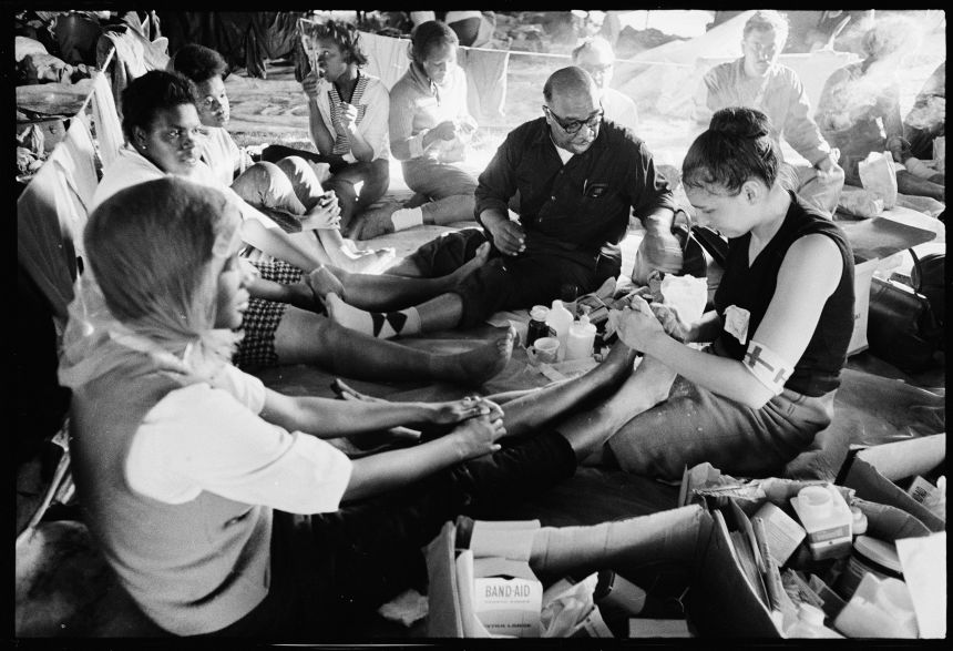 This photo taken by photographer Matt Herron shows Doris Wilson, 20, a resident of Marion, Alabama, getting medical care from Dr. June Finer, one of many volunteer doctors who escorted marchers along their 54-mile journey.