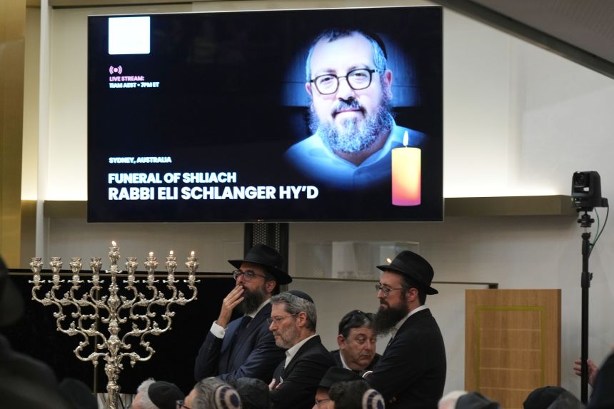 Mourners gather at a synagogue for the funeral of Rabbi Eli Schlanger, a victim in the Bondi Beach mass shooting, in Bondi in Sydney on December 17, 2025.