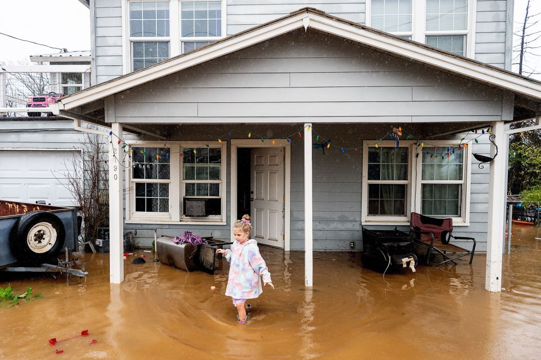 Aria Wogoman leaves her flooded home following heavy rains in Redding, California, on Monday.