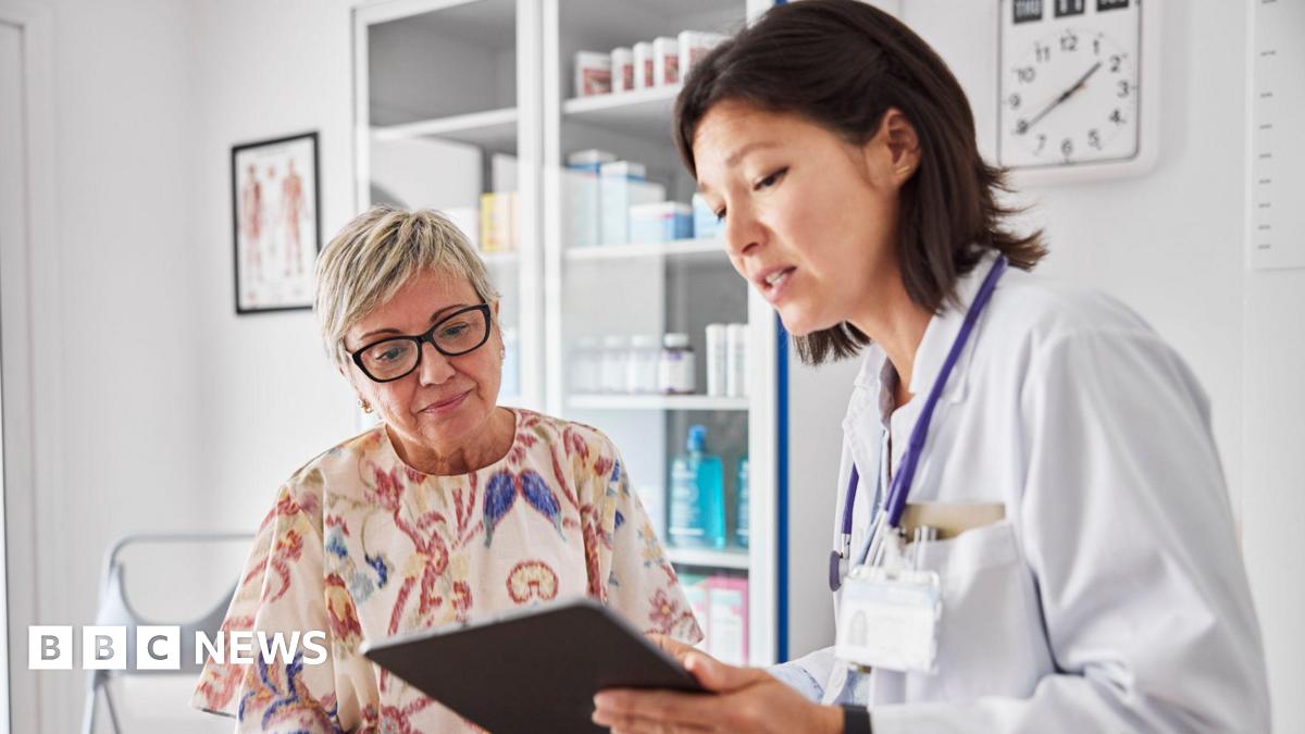 A brown haired Female doctor sharing electronic test results with light haired female patient at a clinic. Medical expert and woman are examining reports. They are sitting in examination room.
