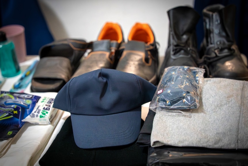 Someone's belongings including shoes and a hat neatly laid on a table.