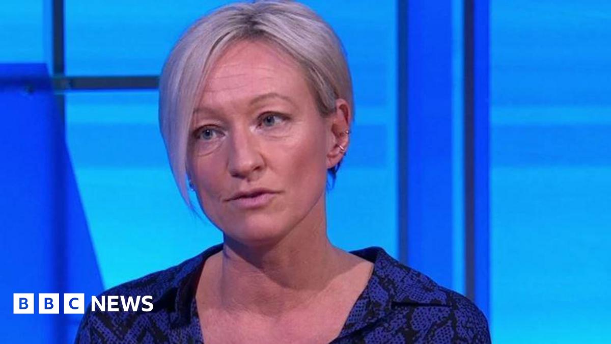 A middle-aged woman with blonde bobbed hair and blue patterned shirt.