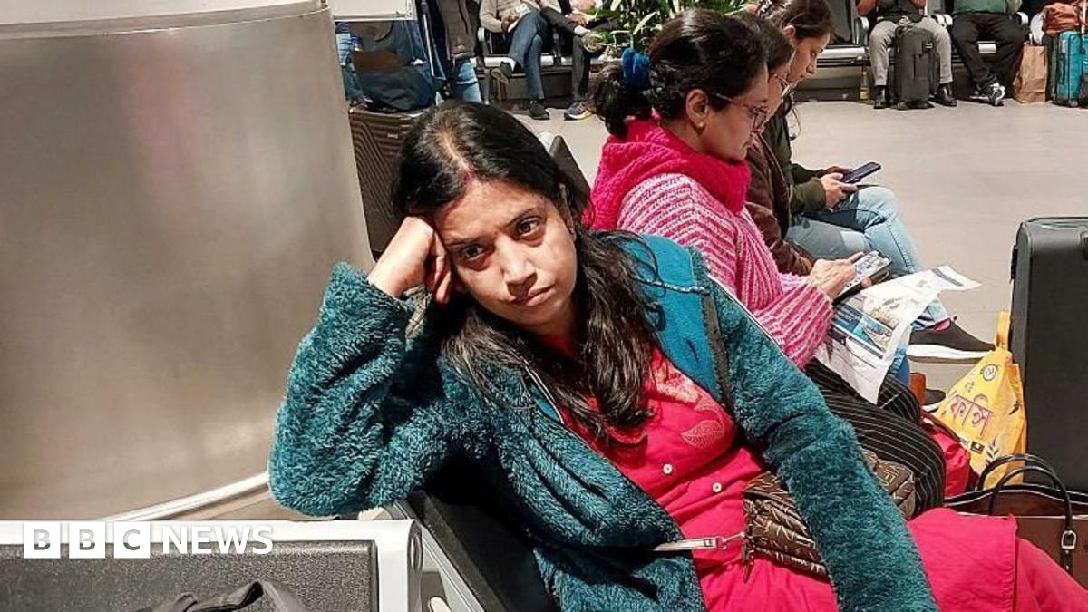 Passengers wait near the IndiGo Airlines kiosk at the Chennai International Airport in Chennai on December 5, 2025. Chaos gripped Indian airports on December 4 after the country's biggest airline IndiGo cancelled over 1,200 flights, stranding thousands of passengers