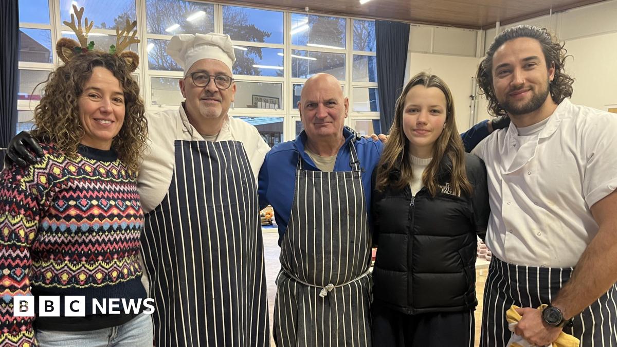 Two women and three men in blue and white aprons standing side-by-side.