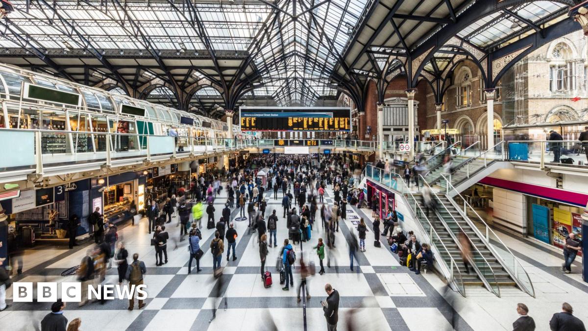 A picture of the concourse of Liverpool Street Station showing it buzzing with passengers.  The picture was taken with a slow shutter speed giving a blur effect.