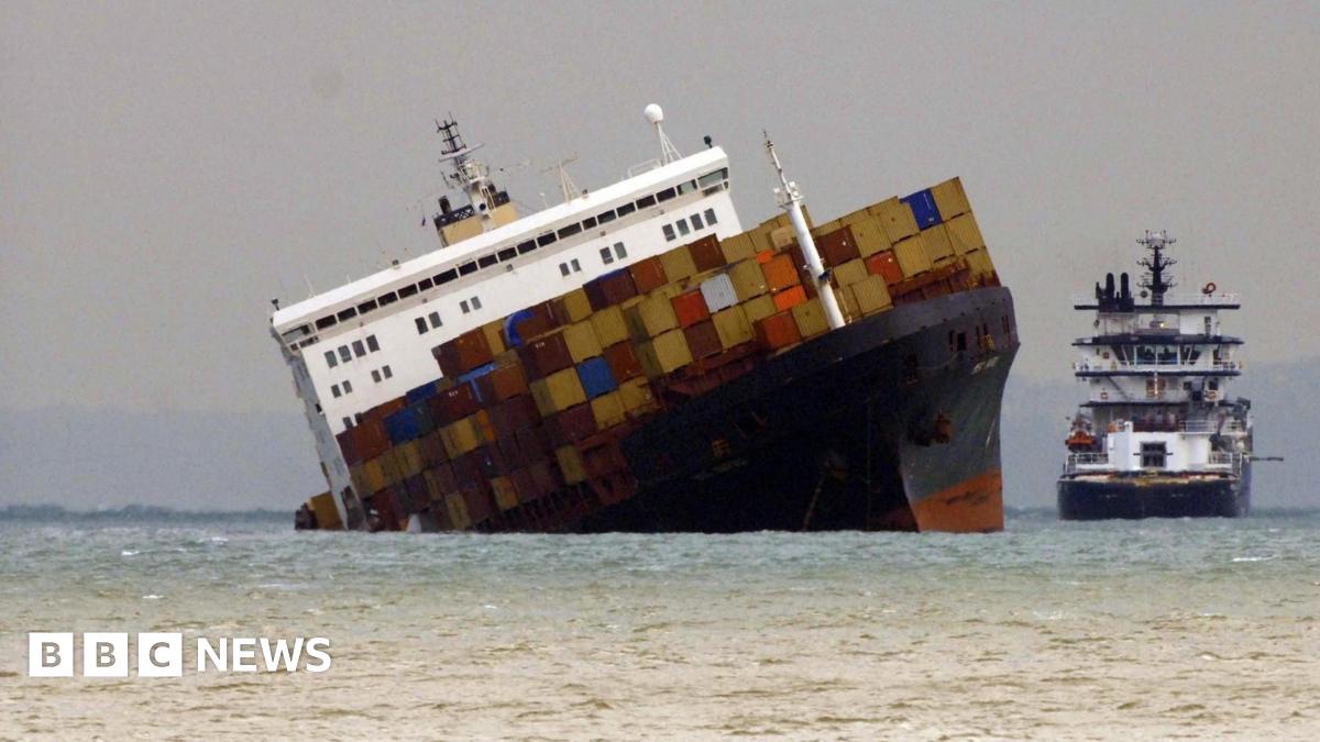 The Napoli lists heavily with containers on the deck and a tug off it's side