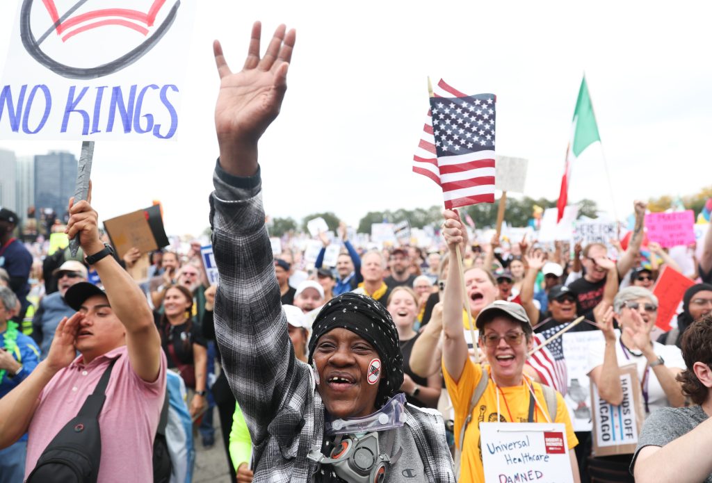 Protesters cheer as Mayor Brandon Johnson speaks during a No Kings Day Protest at Butler Field in Grant Park in Chicago on Saturday, Oct. 18, 2025.