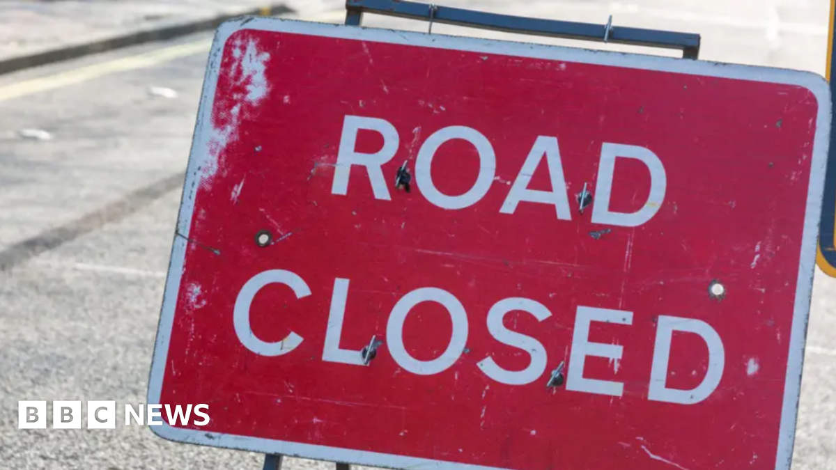 A red Road Closed sign on a street