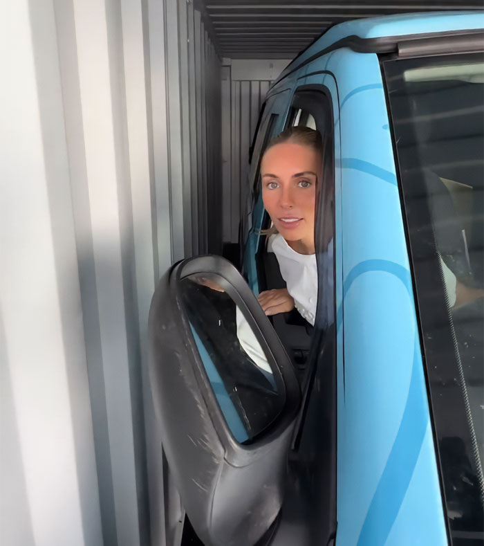 Person leaning out of a blue vehicle inside a narrow container, linked to snitch who reported Bonnie Blue to cops.