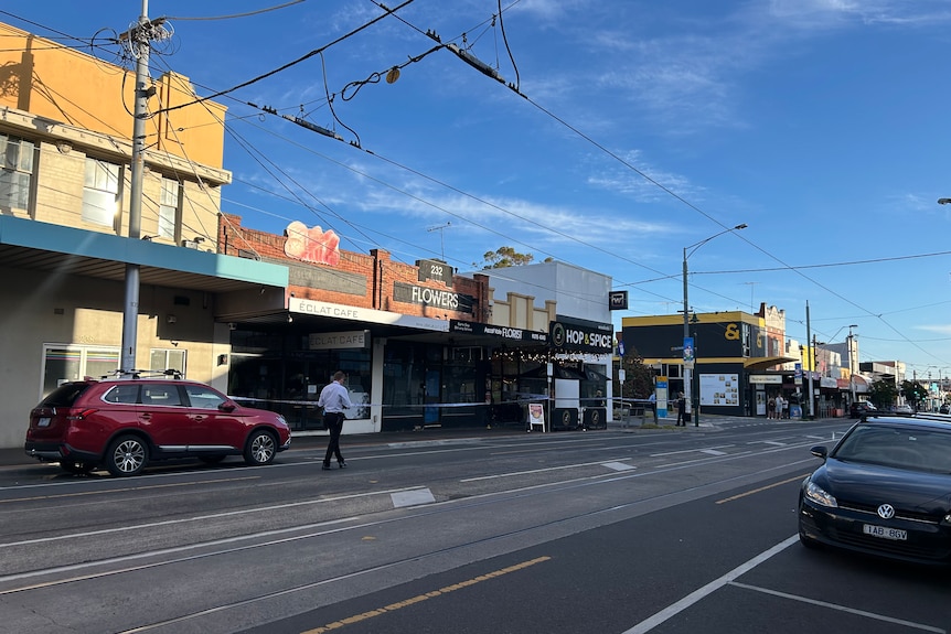 A shopping strip with police tape cordoning off certain areas.