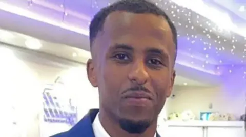 Met Police Mahad Abdi Mohammed in a blue suit.