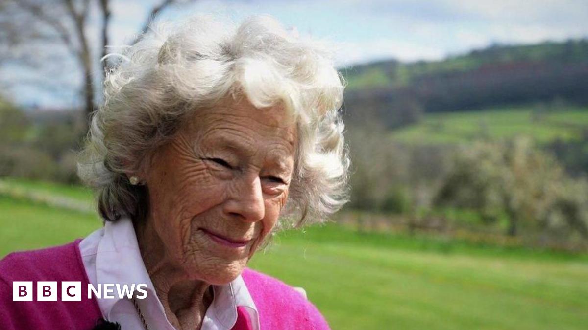 Dame Shân, with short grey hair and wearing a pink jumper and shirt.